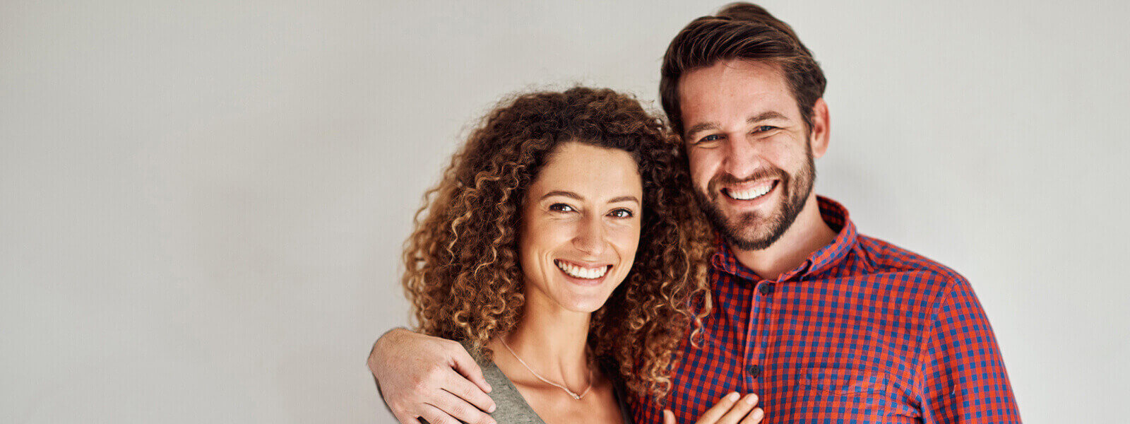 A couple smiling showing their white teeth