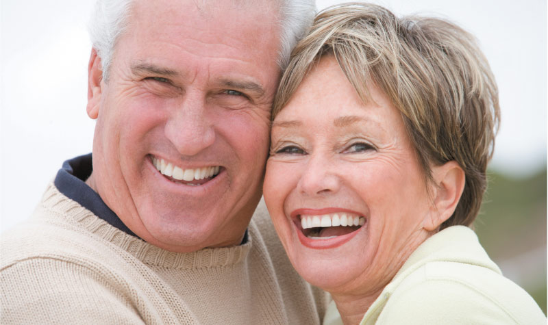 senior couple smiling and laughing after learning how to care for dentures