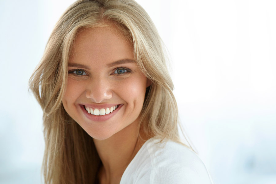 blonde woman smiles showing off her professional teeth whitening results