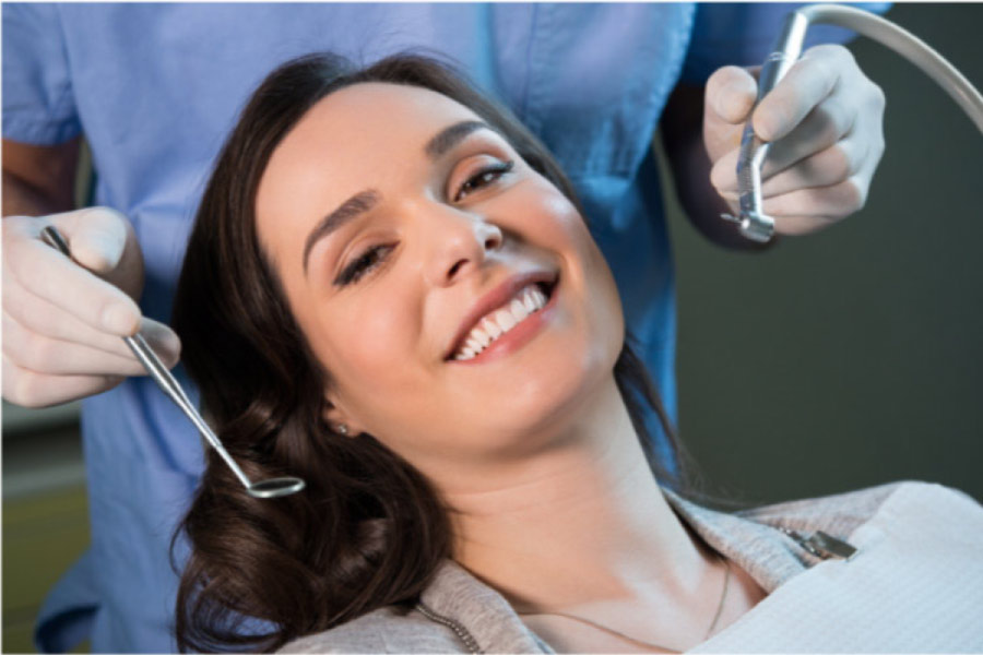 young woman getting a fluoride treatment at the dentist office