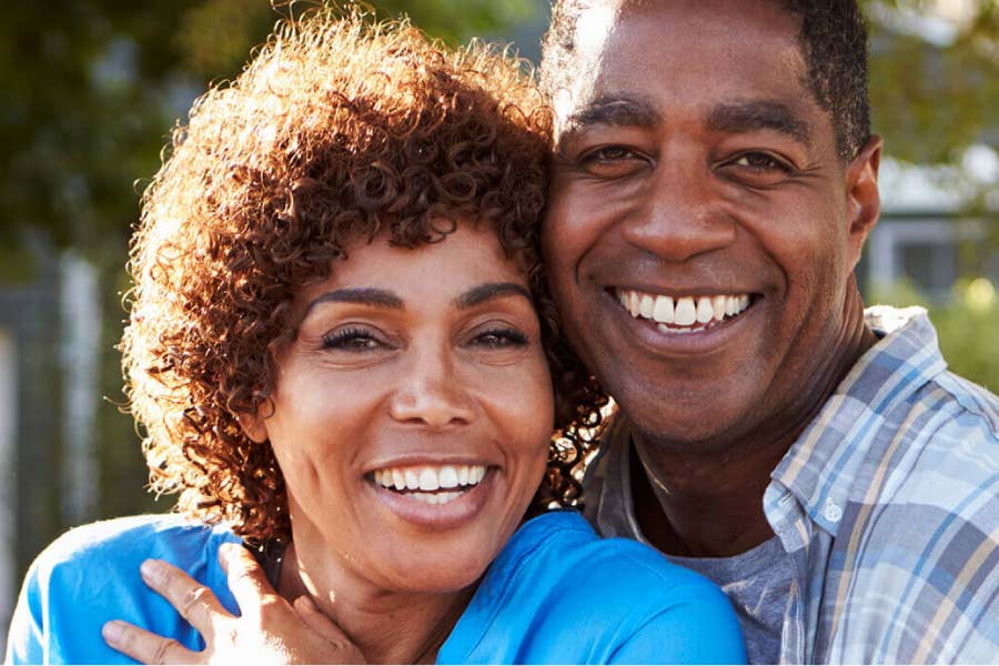 couple hugs and smiles showing off their professionally whitened teeth.