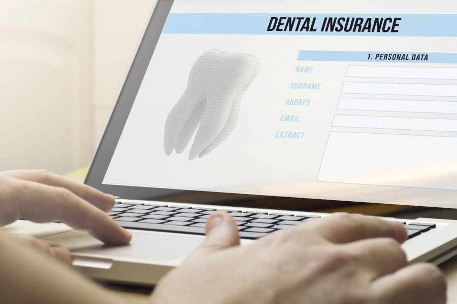 researching dental insurance on a laptop computer