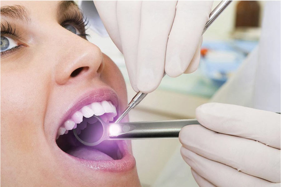 woman undergoing an oral cancer screening at the dentist