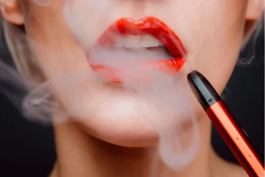 closeup of a woman with bright red lipstick vaping