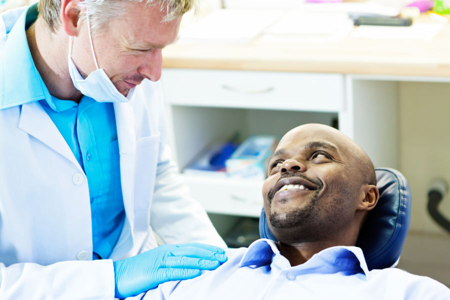 male dental patient gets a gum exam by the dentist