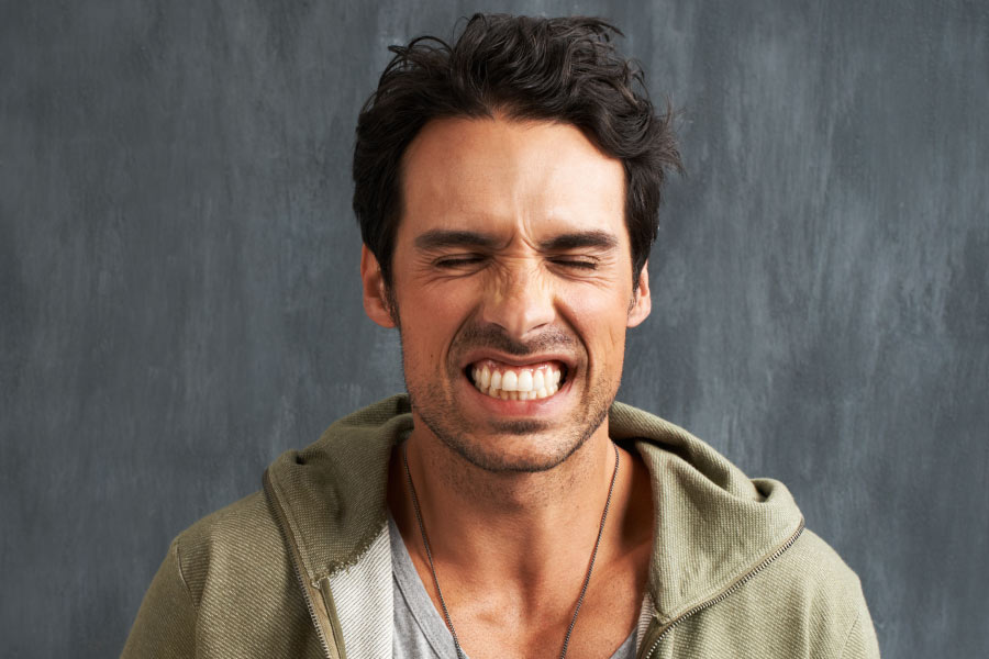 man grinds his teeth damaging oral health