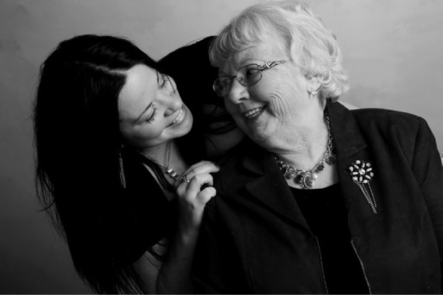 granddaughter laughs with her grandmother about the impact of genetics on oral health 